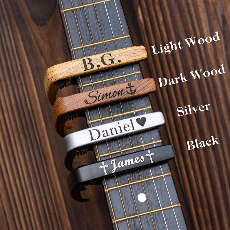 Engraved guitar capos in Light Wood, Dark Wood, Silver and Black