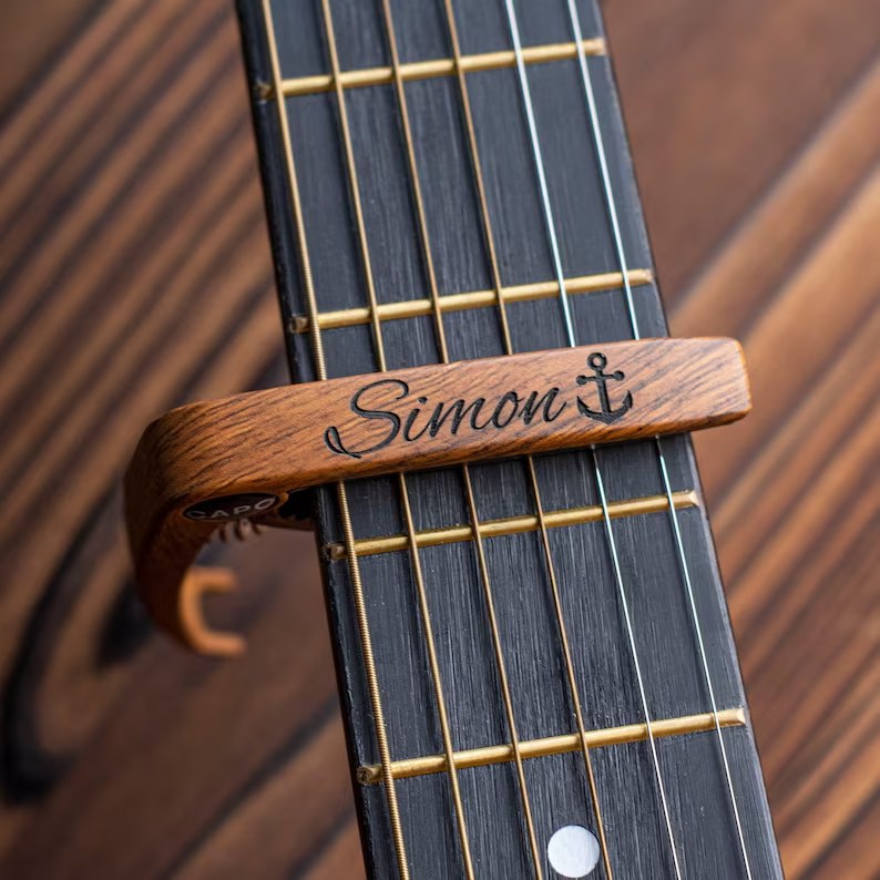 Wooden capo engraved with a name and anchor