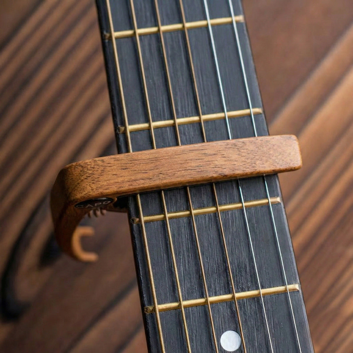 Wooden guitar capo on an acoustic guitar neck