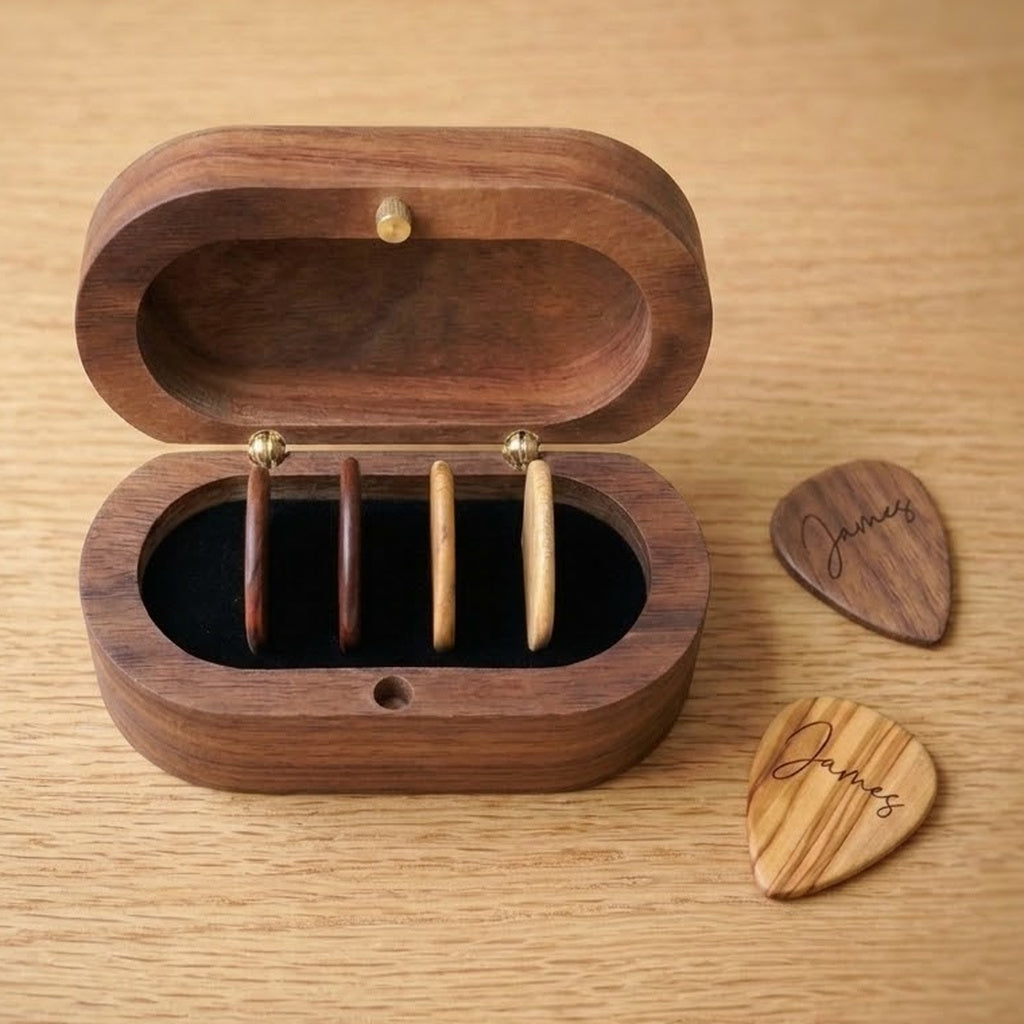 Oval walnut pick box open with four picks stored upright, plus two engraved picks