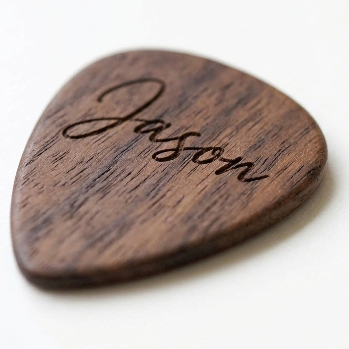 Personalised walnut guitar pick engraved with a name in script