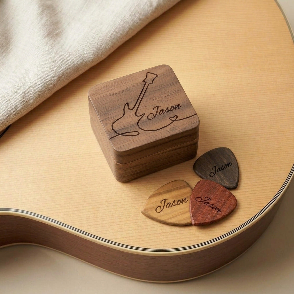 Personalised guitar pick and engraved pick box gift set on an acoustic guitar