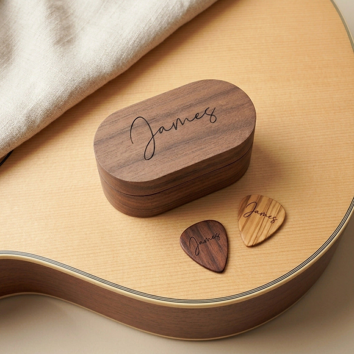 Engraved oval guitar pick box and personalised picks on an acoustic guitar