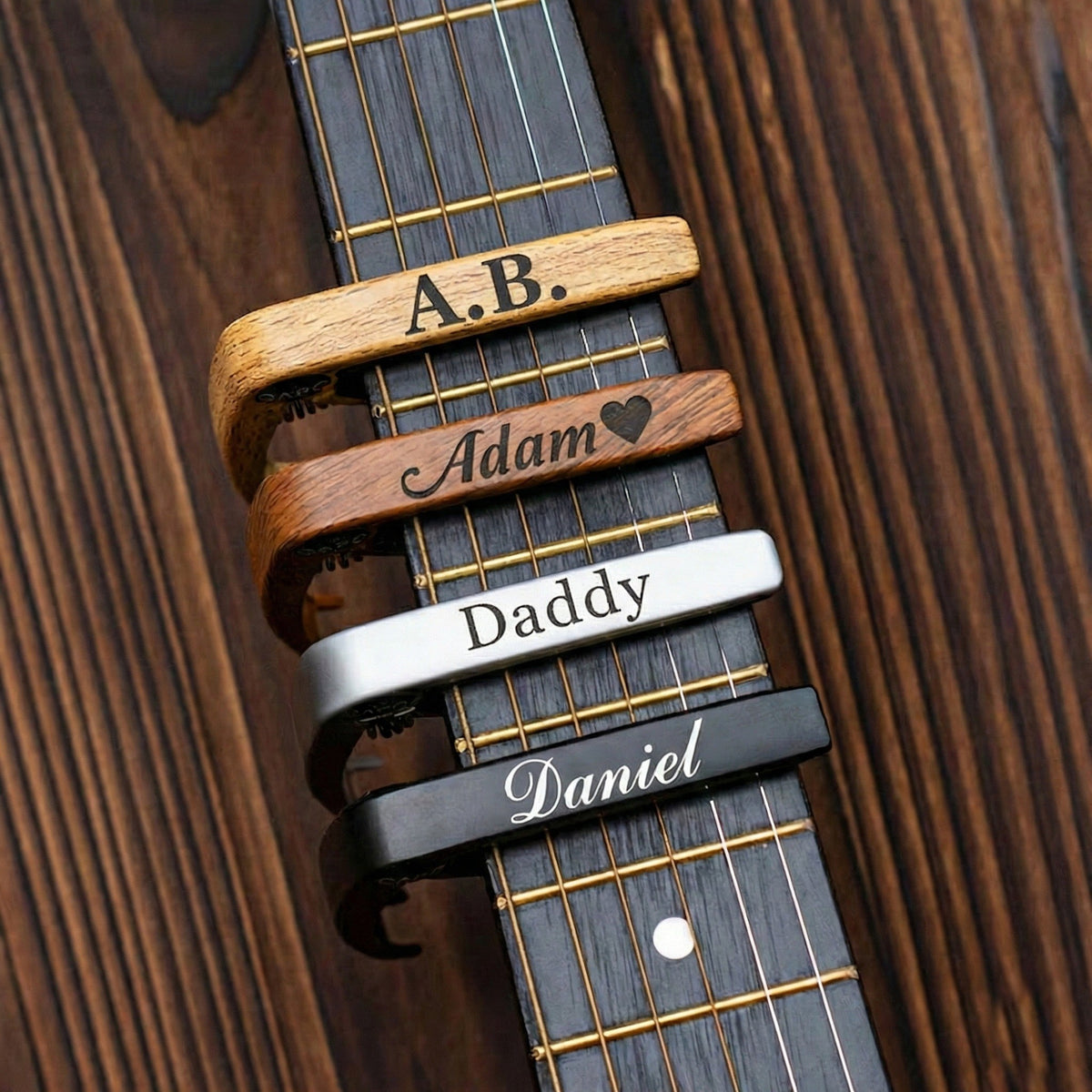 Four personalised capos with engraved names