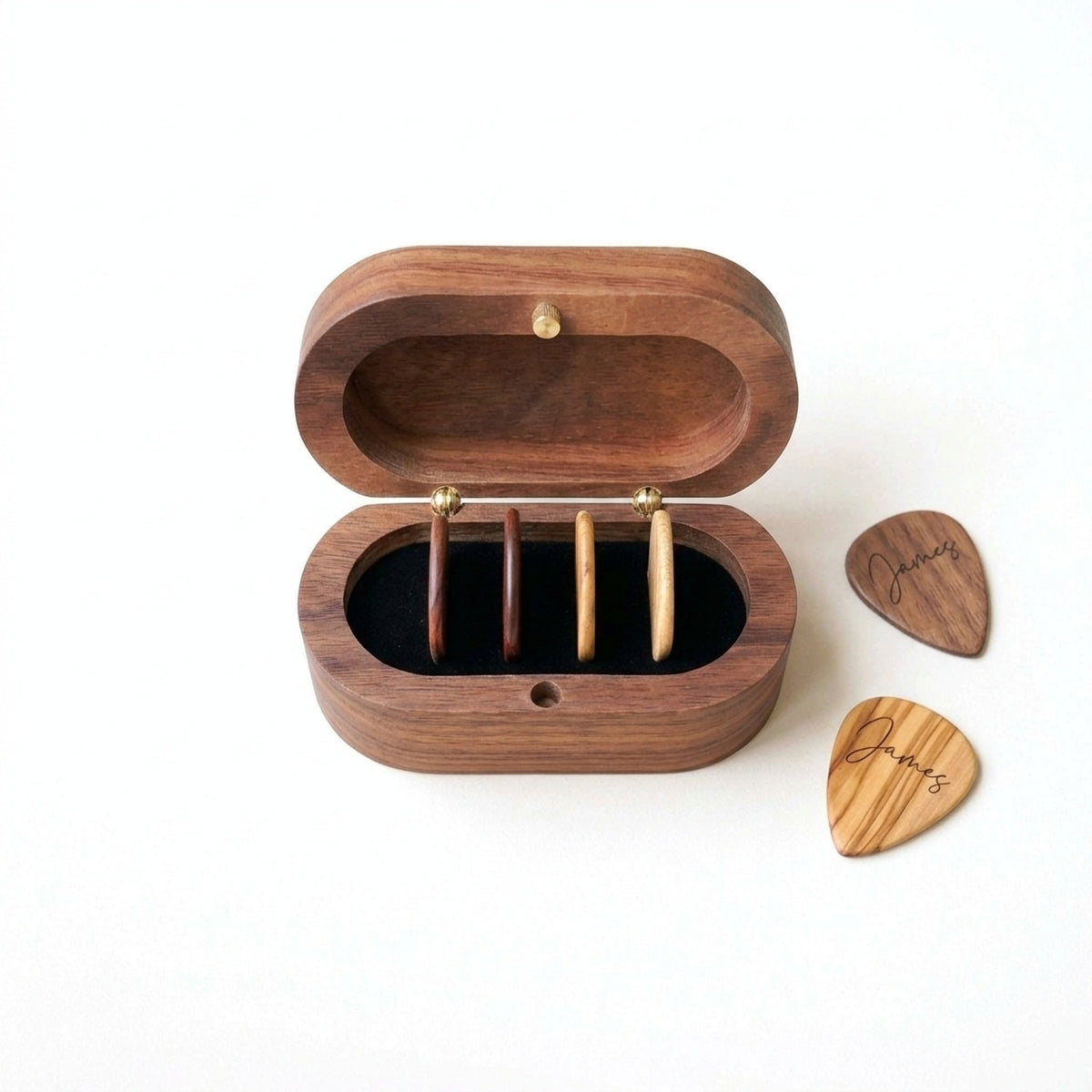 Oval walnut pick box open with four picks stored upright, plus two engraved picks